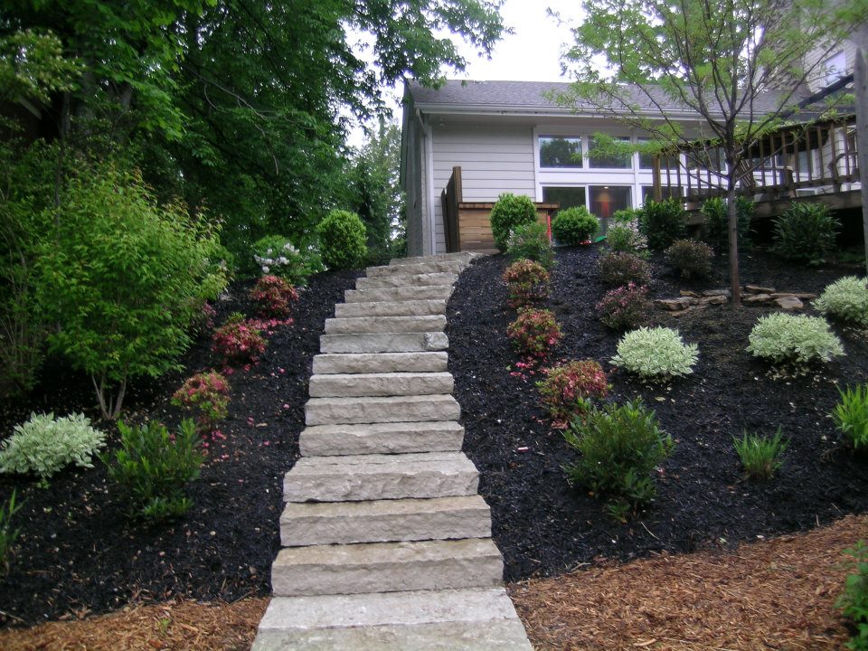 stone steps leading to deck lined with a beautiful landscape